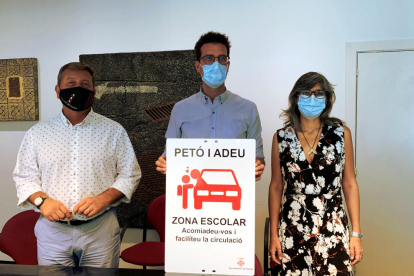 Joan Ramon Castro, Toni Postius y Sandra Castro, con el cartel de la nueva zona 'kiss&ride' de la escuela Espiga