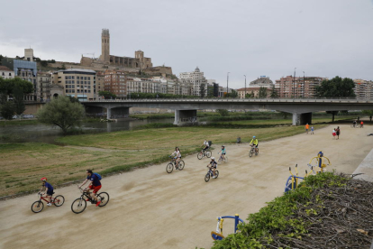 Varios ciclistas ayer por la canalización del río Segre.