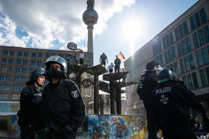 Policías alemanes vigilan a algunos manifestantes que protestaban contra las restricciones.