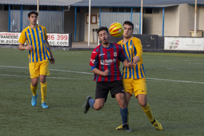 Un jugador del Tàrrega pugna por un balón dividido con un futbolista del Atlètic Sant Just.