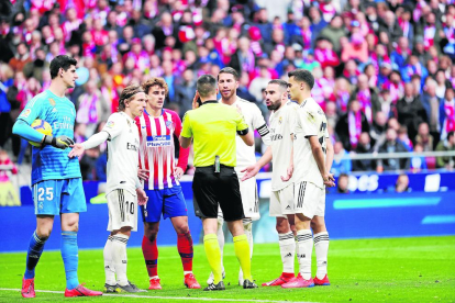 Jugadors del Reial Madrid i de l’Atlètic conversen amb el lleidatà Estrada Fernández, ahir.