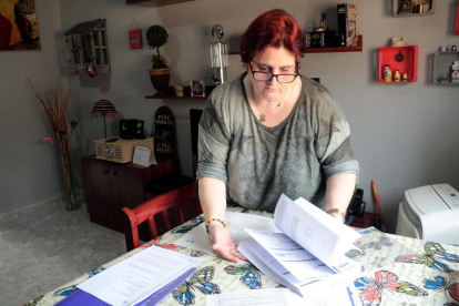 Dolors Ortiz, vecina del barrio de la Bordeta de Lleida, muestra facturas de Endesa en su domicilio.