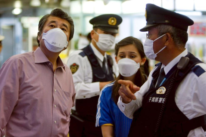 Ciudadanos y policías japoneses usan mascarillas para evitar contagiarse.