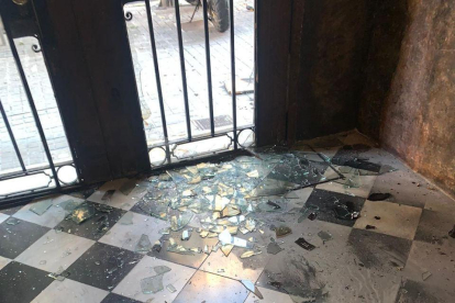 La entrada a la sede de Òmnium en Barcelona con los cristales destrozados y marcas de quemaduras.