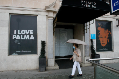 Una mujer pasa por delante de un hotel todavía cerrado en Palma de Mallorca.