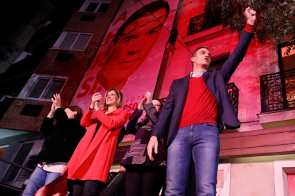 Pedro Sánchez con su esposa, Begoña Gómez, saludando a su militancia tras la victoria del PSOE.