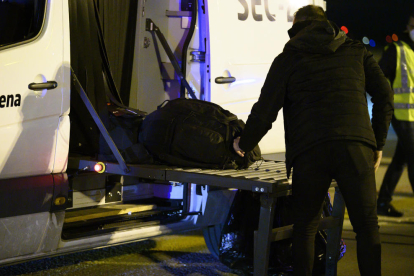Uno de los españoles repatriados de la ciudad china de Wuhan por el riesgo de coronavirus carga maletas en un autobús antes de ser trasladado al hospital por la cuarentena el 31 de enero.