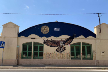 El mural plasma el cel nocturn d’Algerri, una àguila cuabarrada i espigues de cereal.