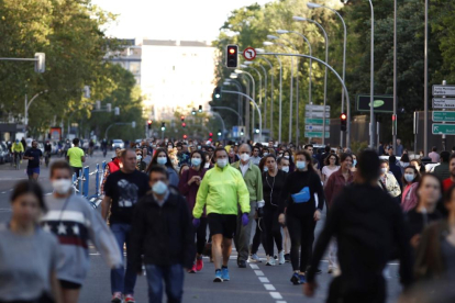 Numerosas personas paseando el domingo por una carretera peatonalizada en Madrid.