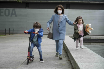 Una mujer pasea junto a dos niños por las calles de Bilbao.