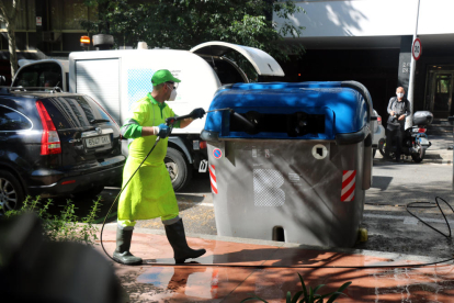 Un operari neteja un contenidor, ahir, al costat dels Jardins de Montserrat, a Barcelona.