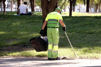 Imagen de un miembro del servicio de limpieza barriendo el parque de la Barceloneta.