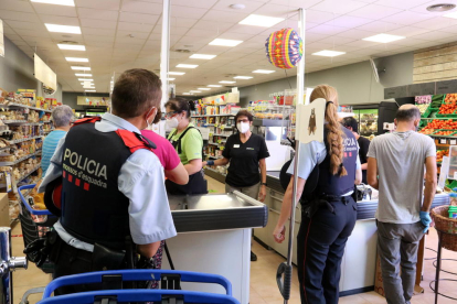 Una parella de Mossos ahir a l’interior d’un dels establiments comercials d’Aitona.