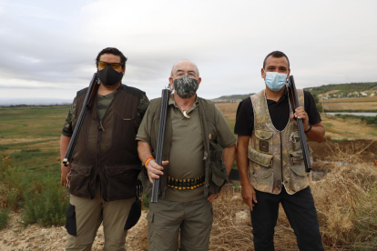 Teixidó (centro), junto a otros dos cazadores en Alguaire. Llevan mascarilla antes y después de cazar.
