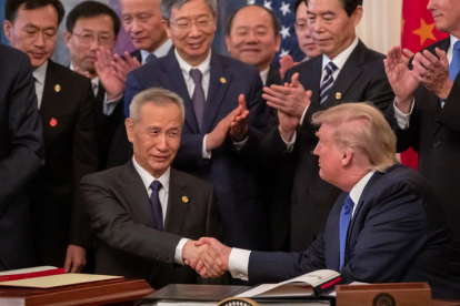 Liu He y Donald Trump se dan la mano tras la firma del acuerdo.