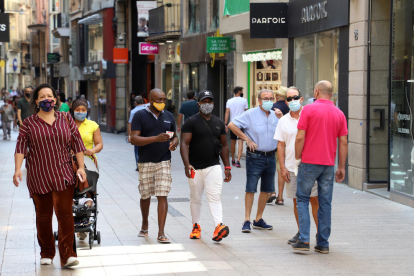 Ciutadans amb les mascaretes posades passejant ahir al migdia per l’Eix Comercial.