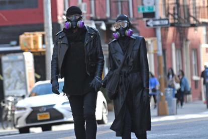 Una pareja con mascarilla y guantes paseando por las calles de Nueva York.