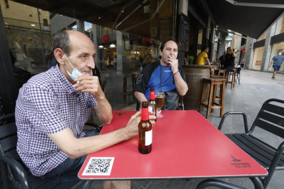 Dos clients d’un bar de l’Eix Comercial fumant ahir a la terrassa mentre feien una cervesa.