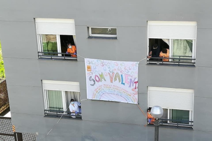 Els treballadors de la residència del Pont de Suert penjant una pancarta a la façana de l’edifici.