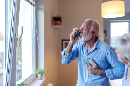 Un home asmàtic fent servir un inhalador.