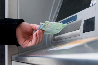 Imagen de un cliente sacando dinero de un cajero automático.