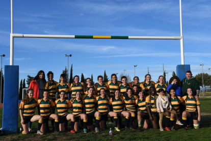 La plantilla de l’Inef Lleida Rugby posa amb el trofeu de campiones de Lliga que els val un ascens.