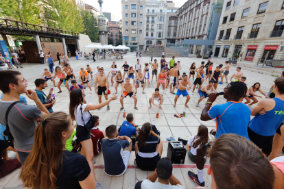 Alumnes bevent i fent flexions com a part de les novatades, ahir a la plaça Sant Joan.