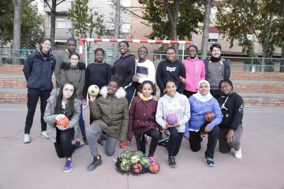 Las jugadoras del equipo infantil de la Associació Lleidatana, junto a sus entrenadores, en el patio de la escuela Balàfia. 