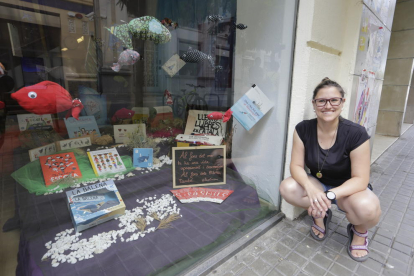 La llibretera d’El Genet Blau, Marina Guillén, al costat de l’aparador distingit per la Setmana del Llibre.