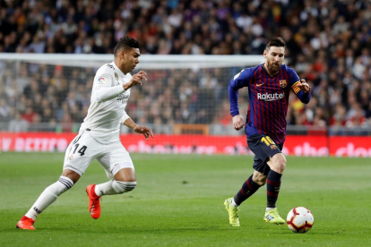 Messi conduce el balón ante Casemiro en un clásico.