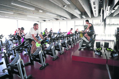 Un operario del gimnasio Trèvol desinfecta una máquina de fitness.