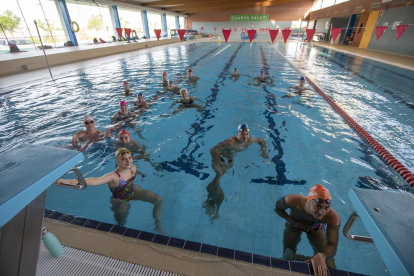 Un operario del gimnasio Trèvol desinfecta una máquina de fitness.