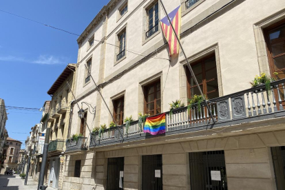 Bandera multicolor ayer en el balcón del ayuntamiento de Les Borges y fachada de la Paeria de Lleida iluminada con los colores del arco iris.