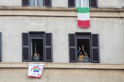 Italianos aplaudiendo ayer a los sanitarios desde sus casas. 