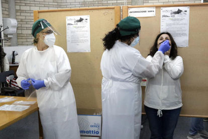 Técnicos sanitarios realizan una recogida de muestras a una paciente en un instituto de Girona.