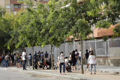 Imatge de grups de pares esperant davant les portes de dos col·legis de Lleida aquesta setmana. Ara, els centres no els permeten entrar als patis.