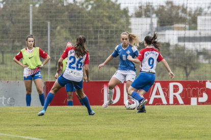 Natàlia, de blau amb el dorsal 11, intenta avançar davant de dos rivals diumenge passat a Gijón.