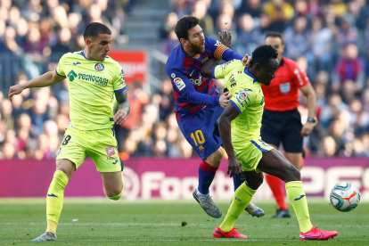Messi és obstruït pel jugador del Getafe Etebo durant el partit d’ahir al Camp Nou.