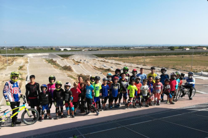 Niños de todas las edades en el circuito BMX de Vila-sana con las pistas al fondo.