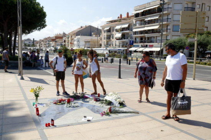 A l’esquerra, persones observen el Memorial per la Pau. A la dreta, concentració de protesta del CDR.