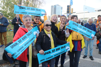 Diversos manifestants amb les cartolines repartides pel Tsunami Democràtic amb el lema 'Spain, sit and talk' a l'entorn del Camp Nou.