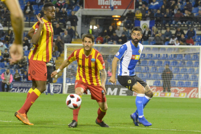 Mousa deixa passar la pilota davant de la mirada de Joan Oriol i d’un jugador de l’equip alacantí.