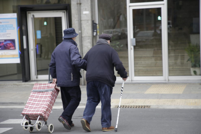 Dos ancianos cruzan un paso de peatones en el barrio de Balàfia. 