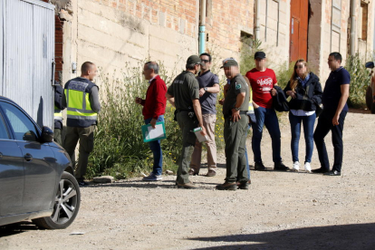 Agents de la policia espanyola amb Agents Rurals a la porta d'accés del magatzem de Bell-lloc d'Urgell on han estat detinguts quatre persones per delictes de tràfic de silurs.