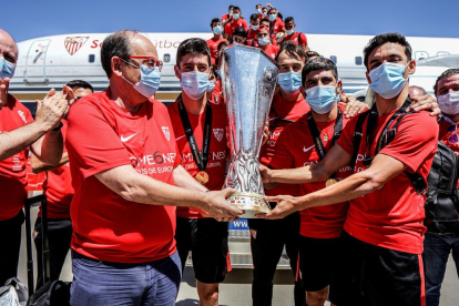 El presidente del Sevilla, Pepe Castro, y el capitán, Jesús Navas, posan con el trofeo tras bajar del avión.