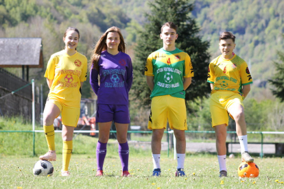 Elena Solà, Laura Riquelme i Eric i Víctor Fernández, amb les samarretes dels seus equips al camp de Vielha, on es van iniciar.