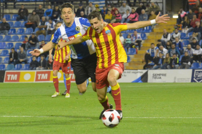 Juanto Ortuño avanza con el balón agarrado por un jugador del Hércules.