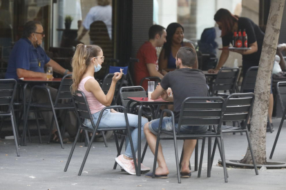 Una joven fumando en una terraza de Lleida un día antes de que entrara en vigor la prohibición. 