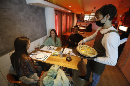 Tres jóvenes disfrutan de una última cena ayer en un restaurante de Lleida.