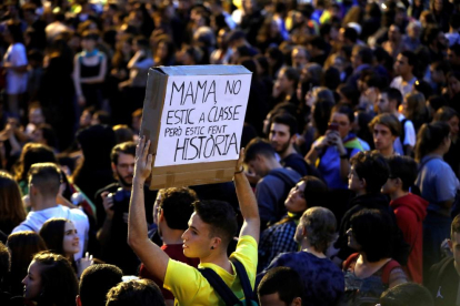 Un jove davant d’una de les barricades incendiades al centre de Barcelona.